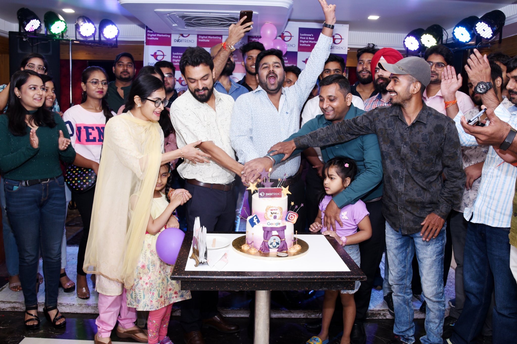 A group of people cutting a cake to celebrate 10 years of DigiTrend Institute’s digital marketing course in Lucknow.